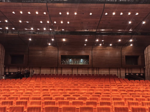 The concert hall with a tiered seating and a wood-based acoustic suspended ceiling