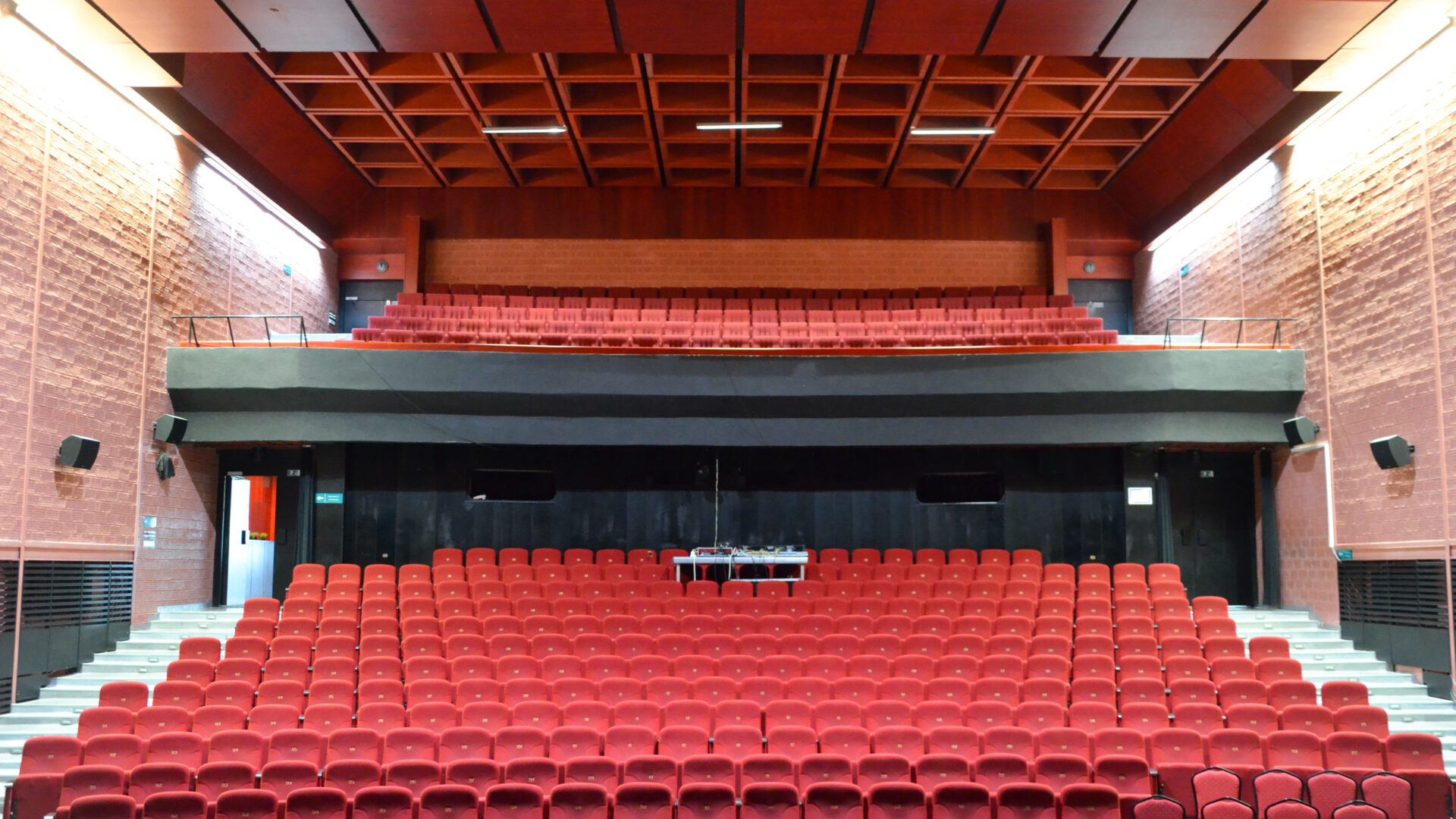 Kino-divadelná sála – rozsiahla červená farebnosť čalúnenia sedadiel vytvára silný výrazový kontrast k javisku a opone stvárnených v čiernej farbe