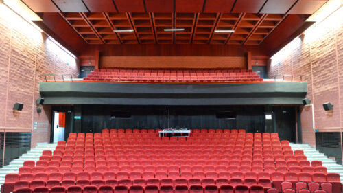 The cinema and theatre hall – the dominant red colour of the seat upholstery is in sharp contrast to the black stage and curtain 