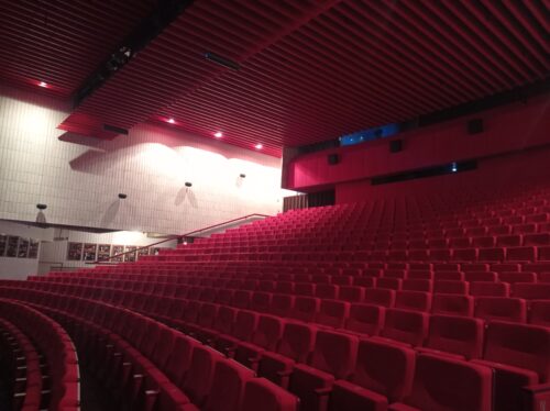 The interior of the concert hall is dominated by the red colour complemented by the warm white colour of the wall facing