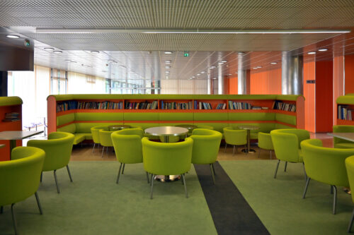 Kaviareň/čitáreň na 1.np. – na mieru navrhnutý interiér dojmovo oživuje svieža zeleno-oranžová farebnosť