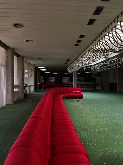 Foyer 2.np. – pôvodnú „divadelnú“ červenú farbu koberca nahradila zelená, tlmené žlto-oranžové tóny čalúnenia sedenia výrazná červená farba