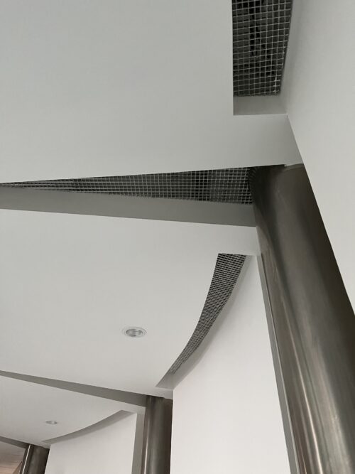 Triangular cut-outs in the soffit reflect the pattern in the granite floor