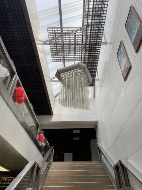 Interiér vstupného vestibulu dnes – priestor schodiska výtvarne dotvára kovovo-sklenený svetelný objekt, steny v jeho okolí sú aktuálne obložené bielym obkladom