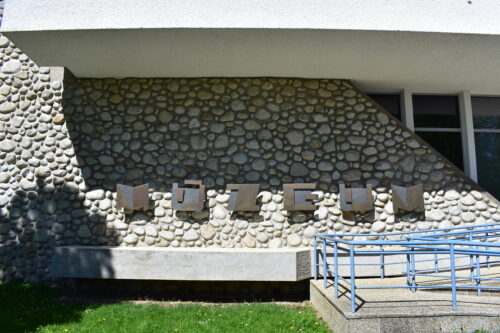 The facade wall of the museum exposition is covered with round river pebble stone; the ramp was added subsequently 