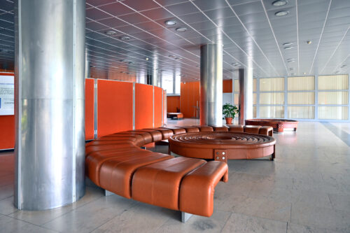 Vestibul prízemia – sedací mobiliár, materialita podlahy a stĺpy obalené antikorom dodnes pripomínajú pôvodnú atmosféru interiéru