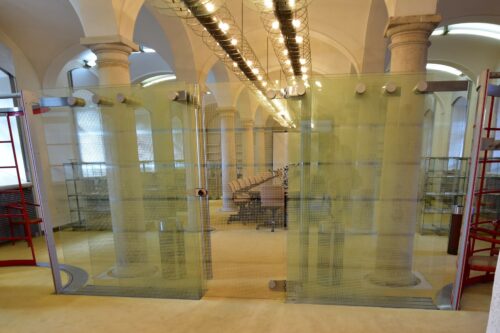 Interiér rokovacej siene oddeľuje atypická sklenená priečka s grafickou potlačou