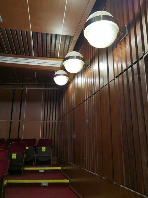 Interiér divadelnej sály charakterizujú nadčasové drevené obklady stien a guľové tvaroslovie nástenných svietidiel