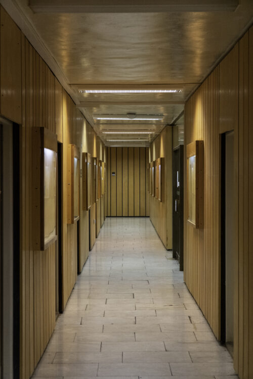 The corridor leading to the library area is characterised by marble floor and the omnipresent wooden wall panelling with added display cases
