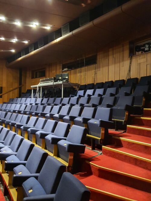 The walls of the theatre hall are artistically decorated with sculpturally structured wooden panelling 