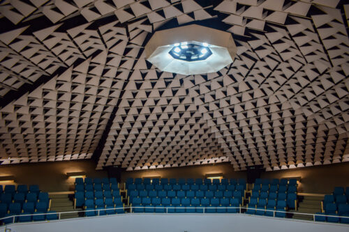 The ceiling plane, which is completed by a geometric play of triangular ceiling plates, is the auditorium's distinctive dominant feature