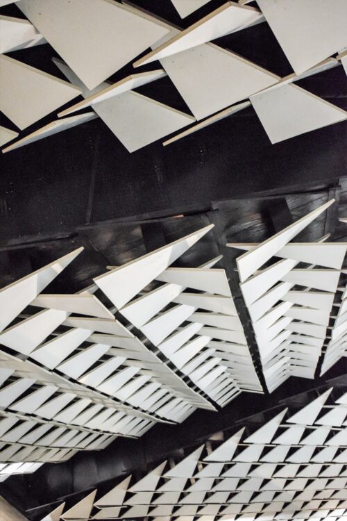 A close-up view of the sculpturally structured suspended ceiling with triangular motifs in the auditorium