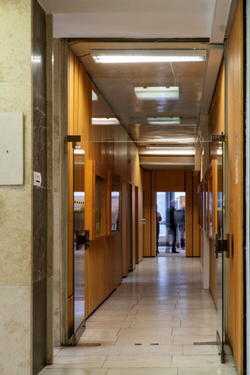 The ground-floor corridors are dominated by marble floors and the omnipresent orange-coloured wall panelling 