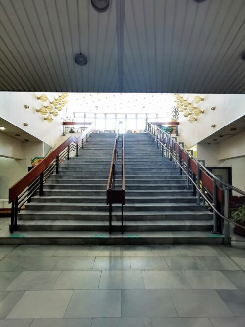 The construction-dominant feature of the lobby is a robust double-flight staircase leading to the second floor