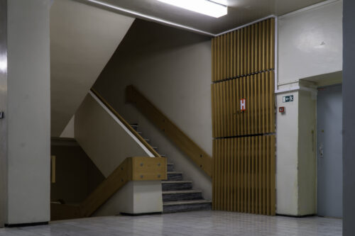 The staircase area is artistically complemented by the timeless wooden slat panelling