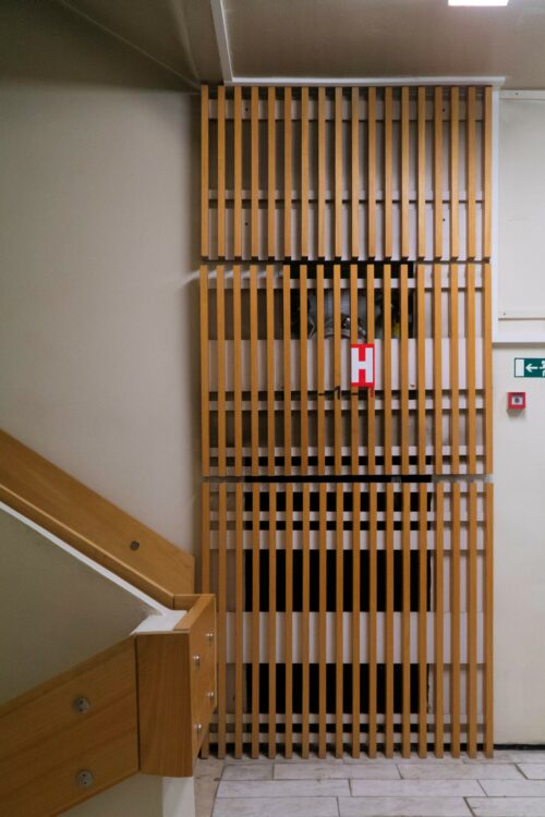 The staircase area is artistically complemented by the timeless wooden slat panelling